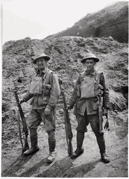 Privates George Giles, left, and John Anderton with their kit as they come out of battle in 1918. Picture: The Australian War Memorial 