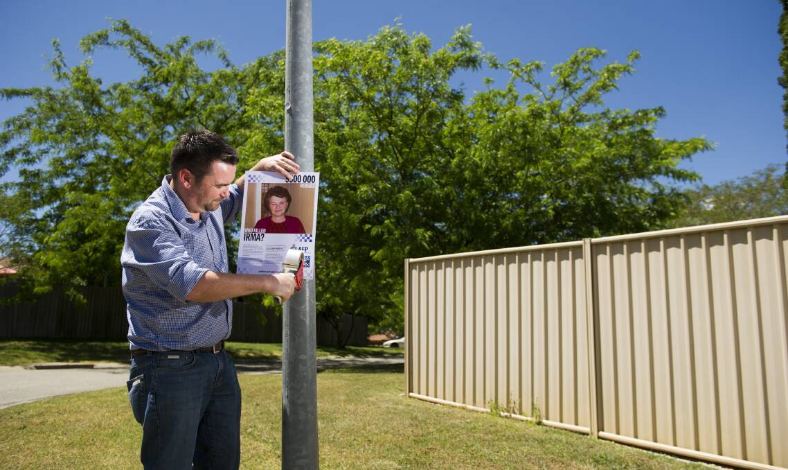 
John Mitika putting up posters around Canberra to remind and encourage people to come forward with information on the murder of this grandmother Irma Palasics.
Picture: Jay Cronan