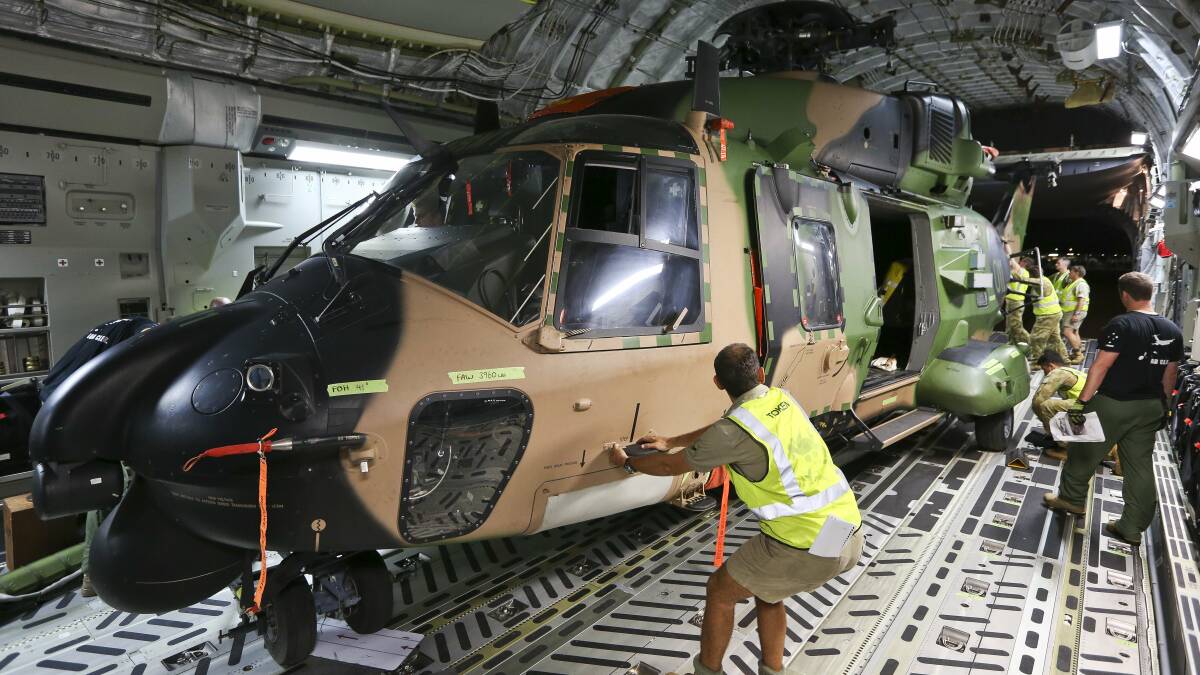 Air Force and Army personnel work together to load a Multi Role Helicopter onto a C-17 Globemaster. Picture: Supplied