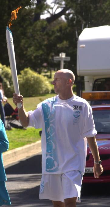 Sydney 2000 athlete Rohan Robinson running with the torch during his leg of the relay. Picture: Gary Schafer