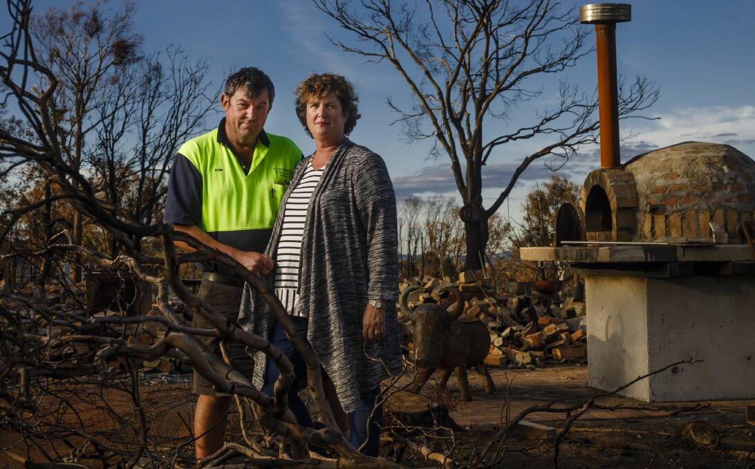 Kevin and Vanessa Lindley among the ruins of their Carwoola home which was destroyed in the 2017 bushfire. They recently joined a class action for compensation. Picture: Sitthixay Ditthavong
