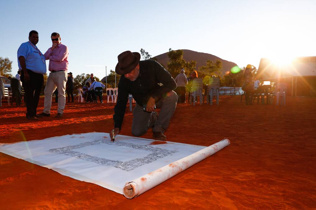 Noel Pearson signs the canvas where the Uluru Statement from the Heart will be painted on in 2017. Picture: Alex Ellinghausen