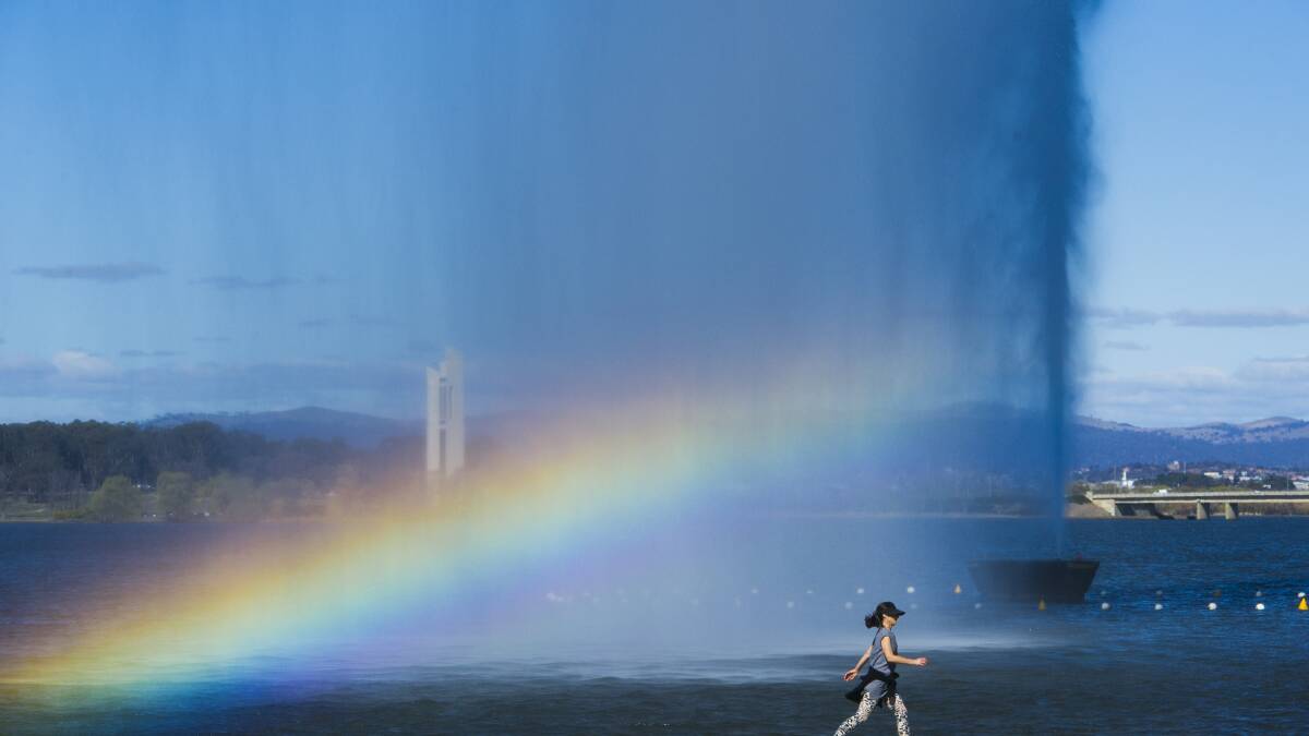 A walker passes a rainbow in the Captain Cook Jet.