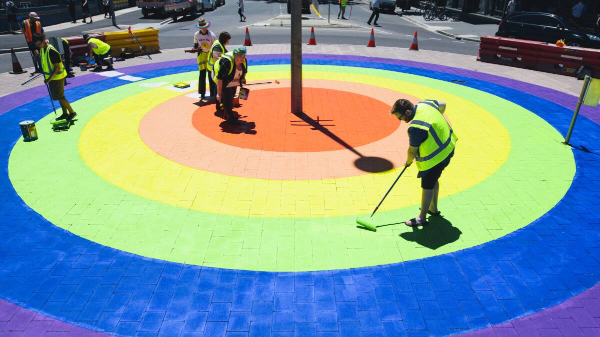 Members of the community paint the finishing touches on the rainbow roundabout in Braddon in November 2017. Picture: Rohan Thomson