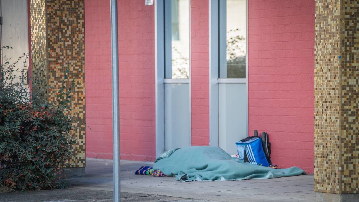 A homeless person sleeps rough outside the ACT Legislative Assembly. Picture: Karleen Minney