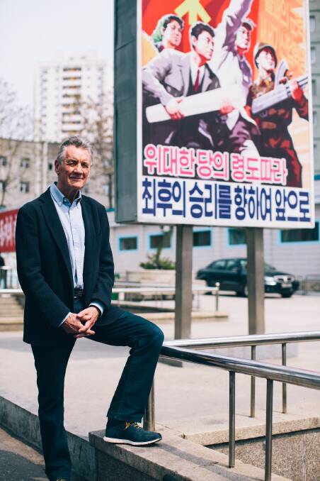 North Korea - Michael Palin next to a propaganda poster. Picture: ITN Productions
