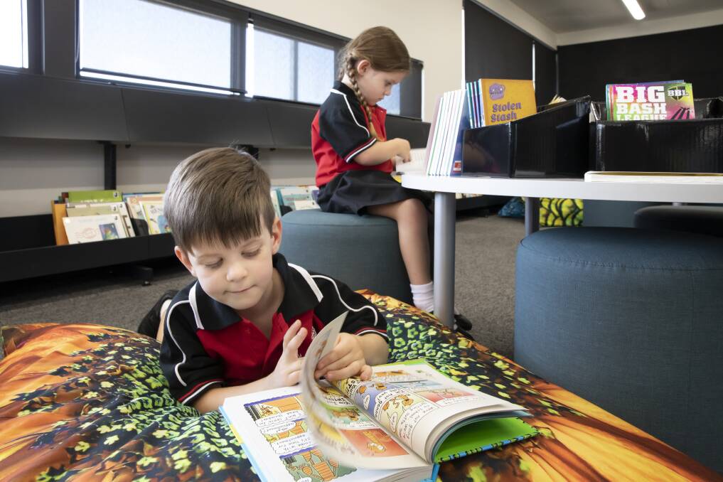 Three-year-old twins Saxon and Scout Phillips from Casey check out the library at the new Margaret Hendry school. Photo: Sitthixay Ditthavong