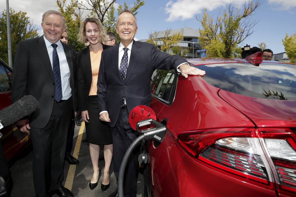 Anthony Albanese, Labor candidate for Canberra Alicia Payne and Bill Shorten view an electric car at a charging station. Photo: Alex Ellinghausen