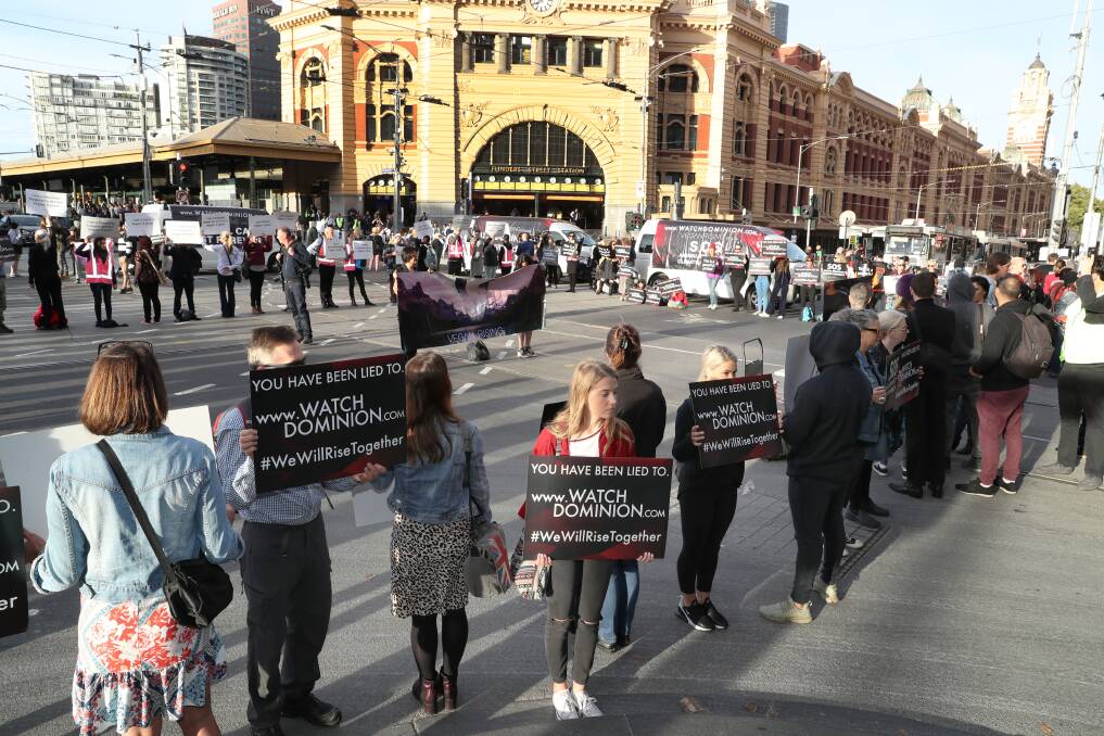 Animal rights protesters block the intersections of Flinders and Swanston Street during early morning traffic in Melbourne on Monday. Photo David Crosling. 