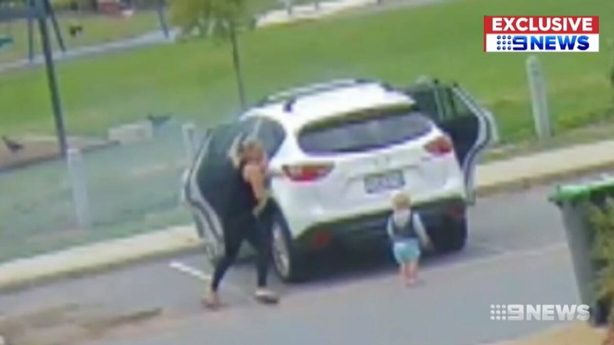 A screencap of the moment Canberra mother Catherine Mayes pulled her two children from her car before it burst into flames.