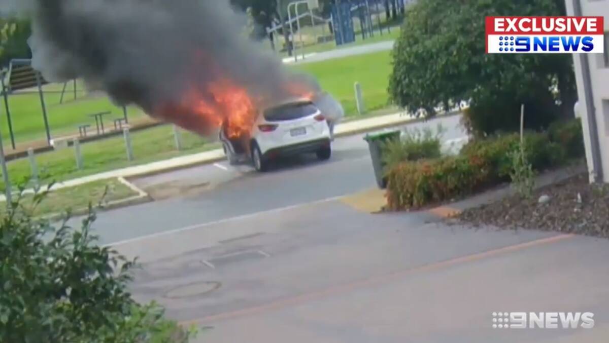 A screencap of the moment Canberra mother Catherine Mayes pulled her two children from her car before it burst into flames. 