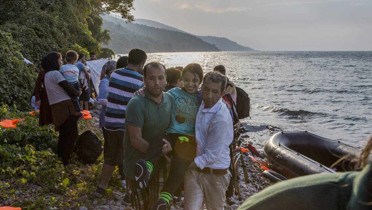 Nujeen is lifted from the shore-line on the Greek island of Lesbos. Photo: UNHCR/Ivor Prickett