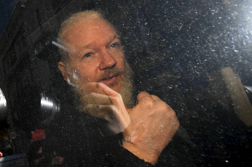 Julian Assange gestures as he arrives at Westminster Magistrates' Court in London, after the WikiLeaks founder was arrested. Photo: Victoria Jones/PA via AP