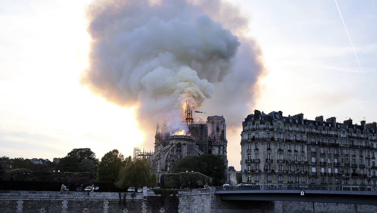 Flames and smoke rise as the spire on Notre Dame cathedral collapses in Paris on Monday, April 15, 2019. Photo: AP Photo/Diana Ayanna