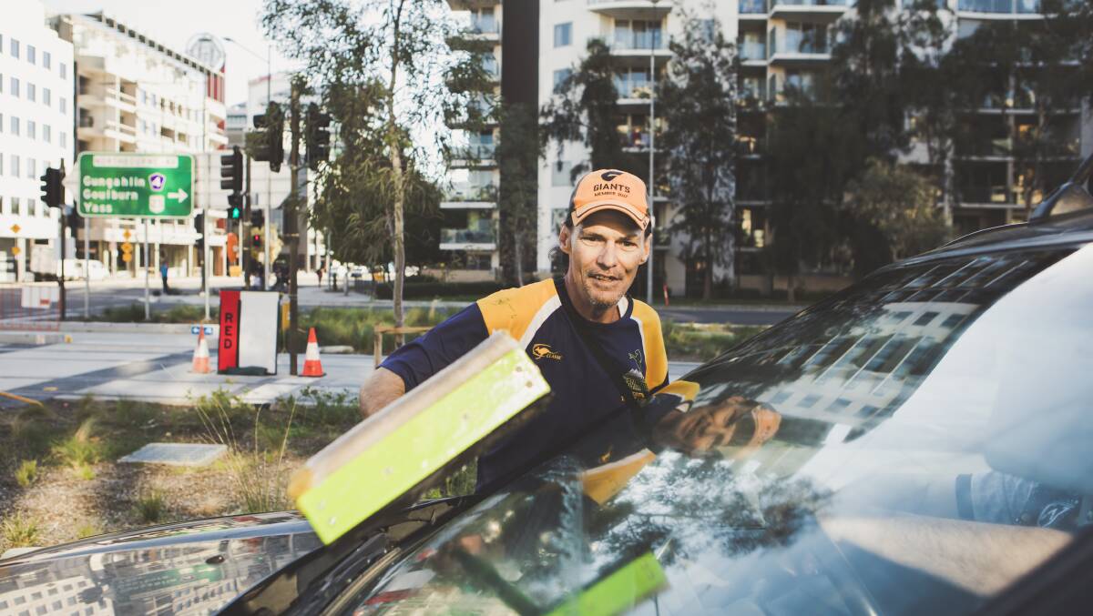 Simon, a window washer on the corner of Northbourne Avenue, and Barry Drive, at work on Wednesday. Photo: Jamila Toderas