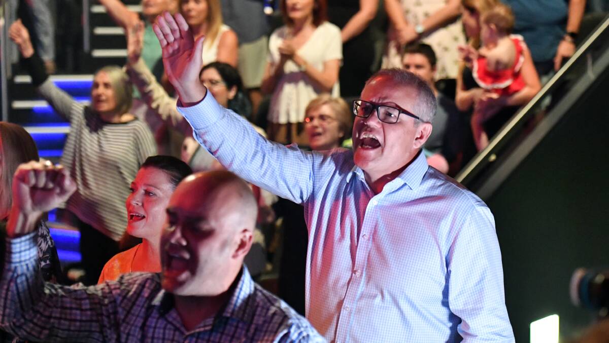 Prime Minister Scott Morrison and wife Jenny sing during an Easter Sunday service at his Horizon Church. Photo: AAP