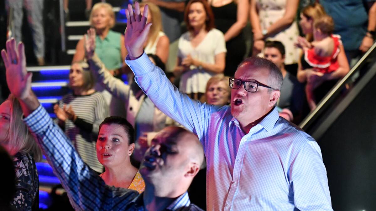 Prime Minister Scott Morrison and wife Jenny sing during an Easter Sunday service at his Horizon Church. Photo: AAP