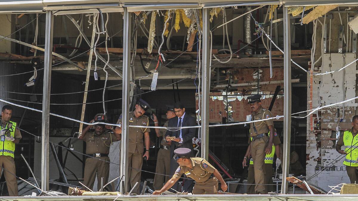 A Sri Lankan Police officer inspects a blast spot at the Shangri-la hotel in Colombo. Photo: Chamila Karunarathne/AP