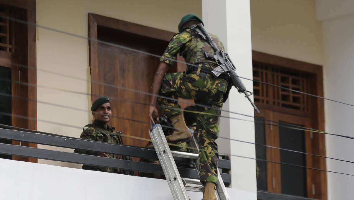A Sri Lankan police commando enters a house suspected to be a hideout of militants following a shoot out in Colombo. Photo: Eranga Jayawardena/AP