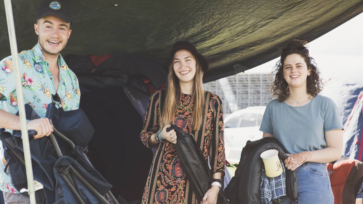 Dean Arvonen, 22, Hannah Van Boxsel, 21, and Emma Lormier, 21, all of Canberra, pack up their tent after spending five days volunteering at Canberra's National Folk Festival. Photo: Jamila Toderas