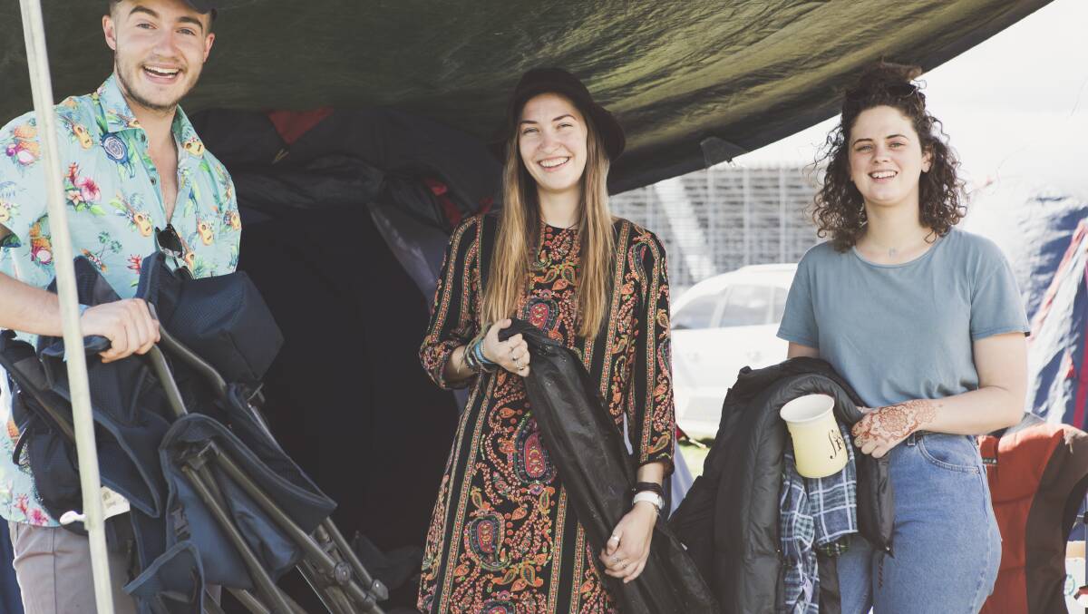 Dean Arvonen, 22, Hannah Van Boxsel, 21, and Emma Lormier, 21, all of Canberra, pack up their tent after spending five days volunteering at the National Folk Festival. Photo: Jamila Toderas
