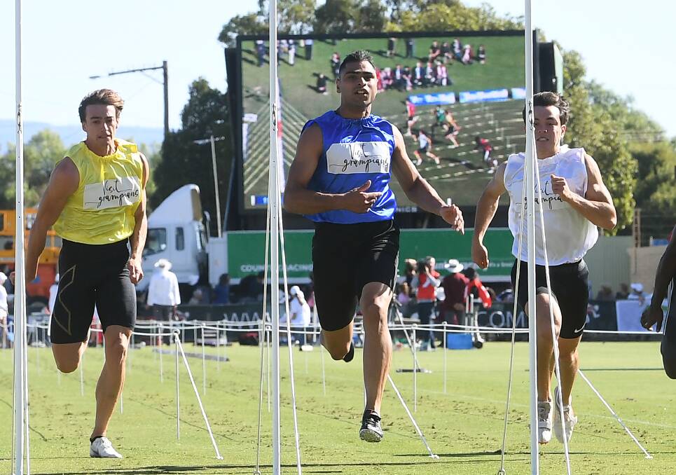 Dhruv Rodrigues-Chico, in blue, won the men's Stawell Gift final. Photo: AAP