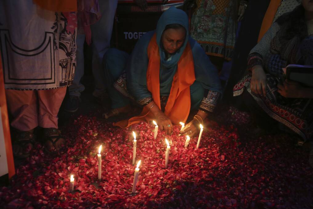 A Pakistani woman lights candles during a vigil for the victims of bomb explosions in churches and hotels in Sri Lanka. Photo: AP
