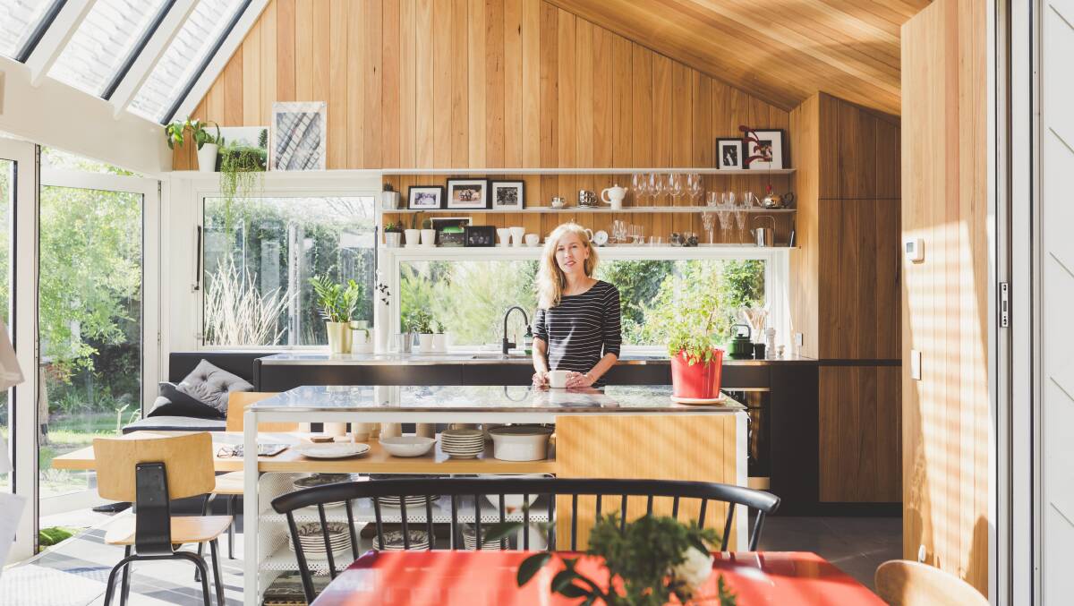Lindy in the kitchen of her Forrest home. Left, glass links to the kitchen and a new bedroom. Photo: Jamila Toderas