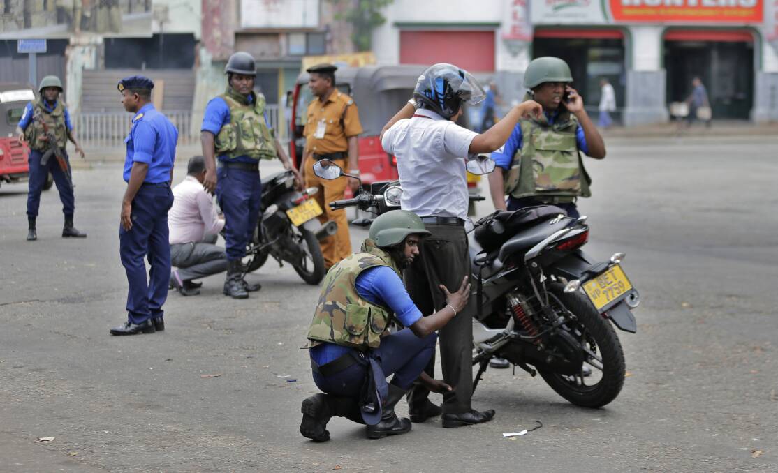 Navy soldiers perform security checks on motorists at a roadside in Colombo. Photo: AP