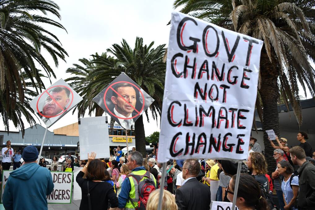 Protesters hold placards during a rally on climate inaction outside the office of Prime Minister Scott Morrison in Cronulla on Friday. Picture: AAP