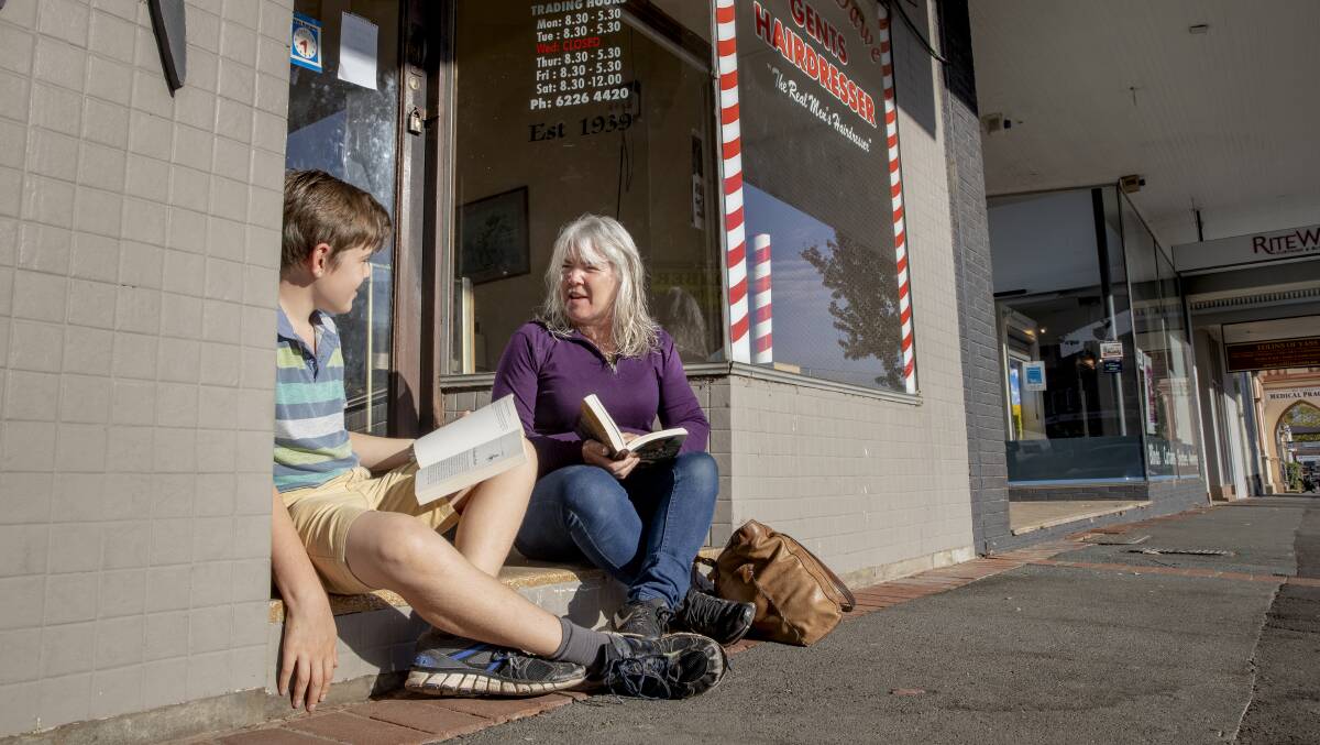 Sandy Giddy, right, waits with her son son Selwyn, 11, for Liberty Salon on the main street in Yass to open. Picture: Sitthixay Ditthavong