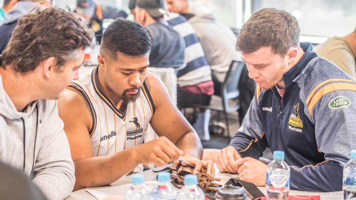 Murray Douglas, right, with Folau Faingaa and Sam Carter work together to make a prosthetic hand. Picture: Karleen Minney