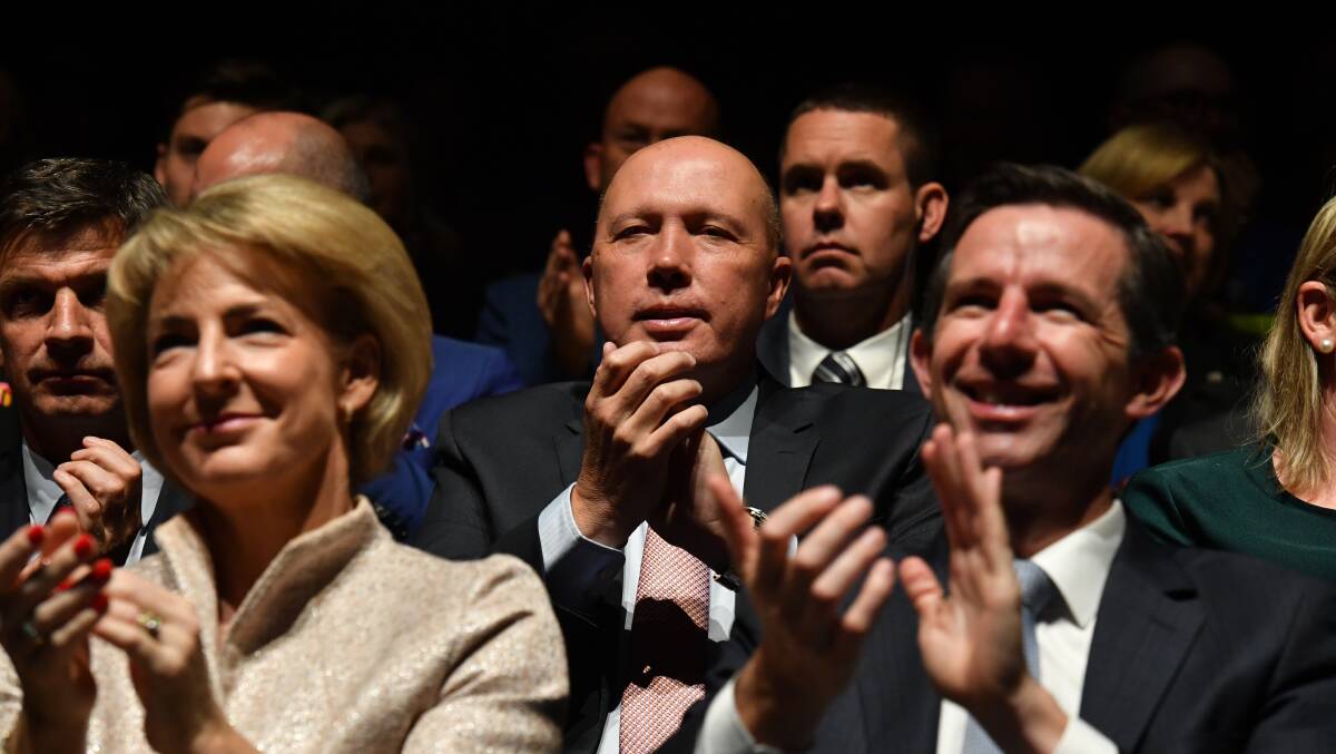 Minister for Home Affairs Peter Dutton (centre) listens to Prime Minister Scott Morrison at the Liberal Party campaign launch in Melbourne on Sunday. Picture: AAP Image/Mick Tsikas