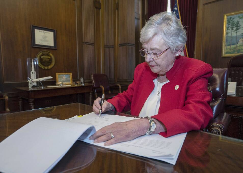 Alabama Governor Kay Ivey signing a bill that virtually outlaws abortion in the state. Picture: AP