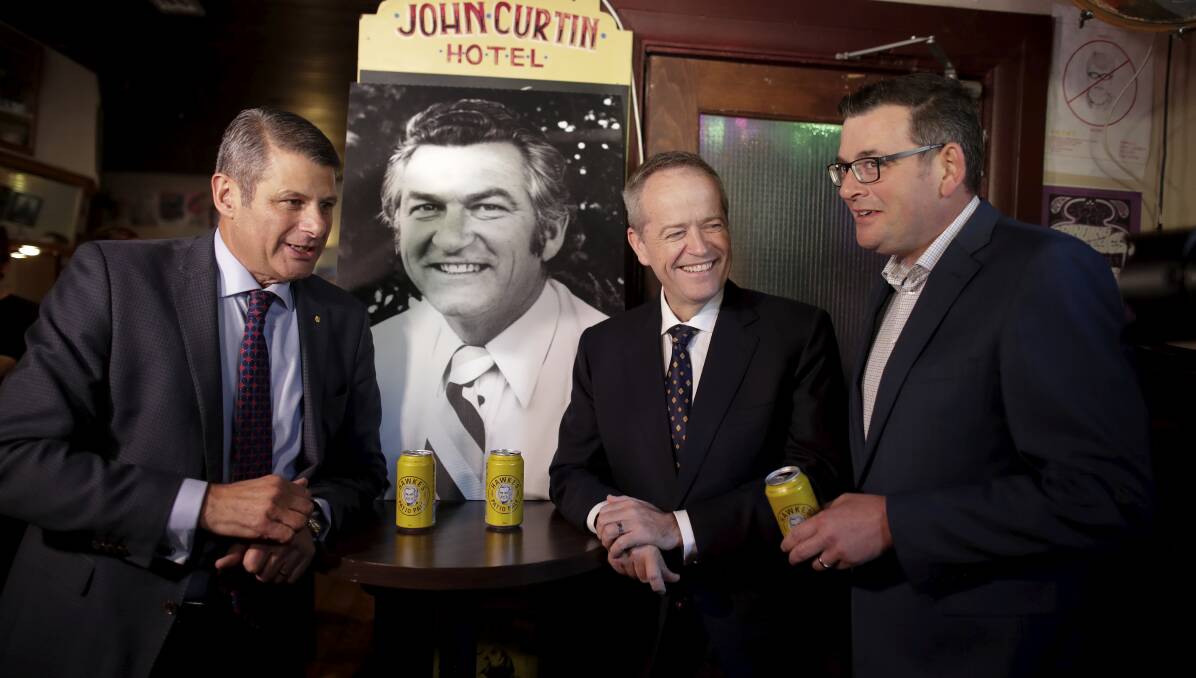 Bill Shorten shares a Hawke's Pale Ale with former Victorian Premier Steve Bracks and current Premier Daniel Andrews on Friday during a brief pause on day 37 of the election campaign at the John Curtin Hotel in Carlton, Melbourne. Picture: Alex Ellinghausen
