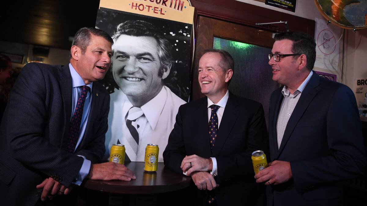 Australian Opposition Leader Bill Shorten (centre), with Victorian Premier Daniel Andrews (right) and former Victorian premier Steve Bracks, has a beer in memory of former PM Bob Hawke at the John Curtin Hotel in Melbourne on Friday. Picture: AAP Image/Lukas Coch