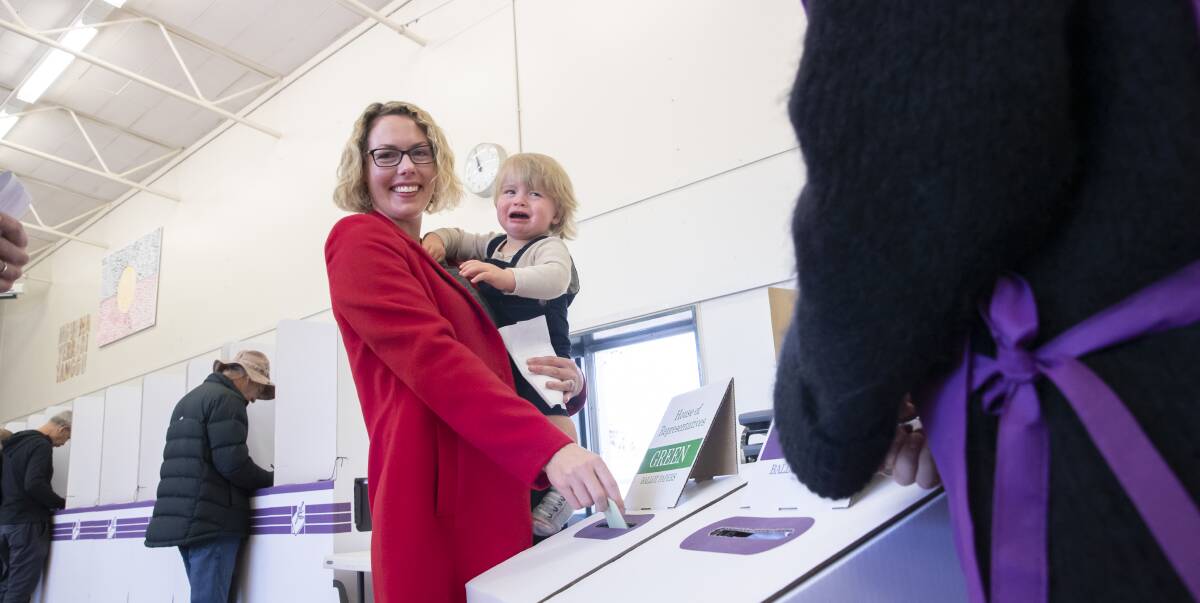 Alicia Payne casts her vote at Lyneham primary school on Saturday, May 18, while her 15-month-old son Paul Phillips is overwhelmed by the occasion. Picture: Sitthixay Ditthavong