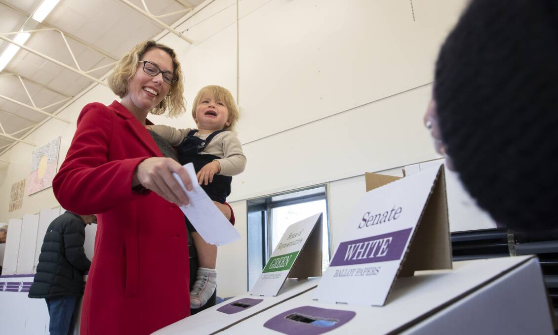Labor's then-candidate for Canberra Alicia Payne casts her vote in May, accompanied by son Paul Phillips. Picture: Sitthixay Ditthavong
