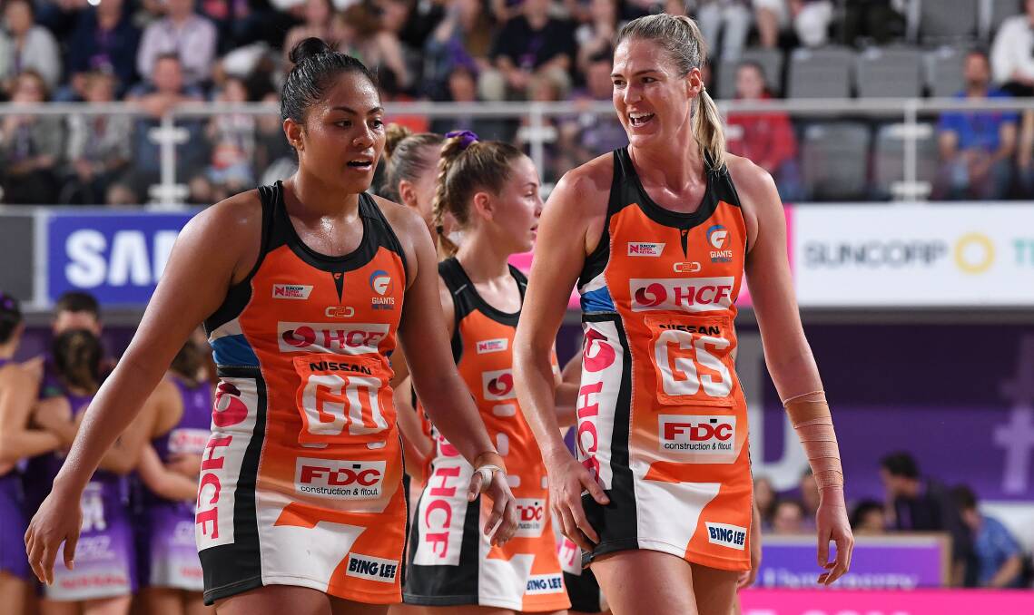 Giants players Kristiana Manu'a (left) and Caitlin Bassett celebrate following their win over the Firebirds. Picture: AAP