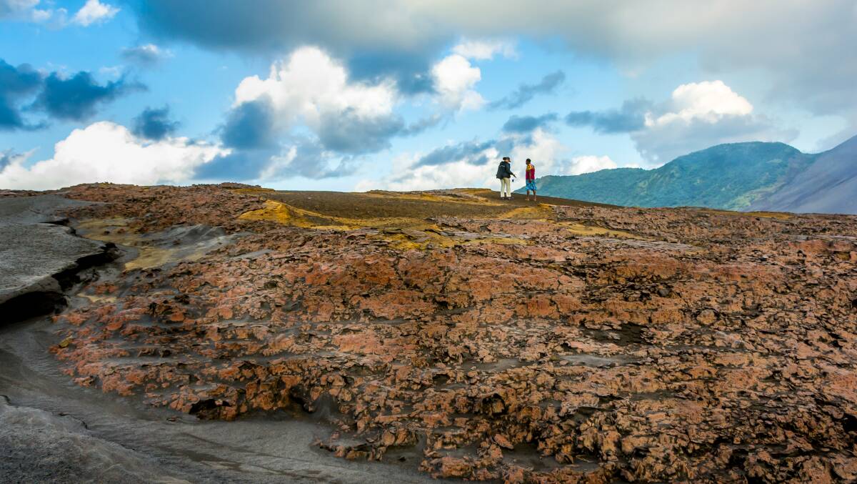 Guides Marc Giraud and Daniel Walgain hike across the volcanic plains. Picture: Supplied
