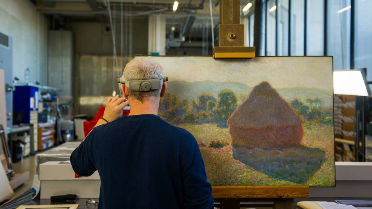 National Gallery of Australia senior conservator David Wise with Claude Monet's Haystacks, midday. Picture: Karleen Minney