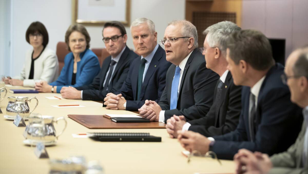 Prime Minister Scott Morrison and Deputy Prime Minister Michael McCormack speak with department secretaries around the cabinet table. Picture: Alex Ellinghausen