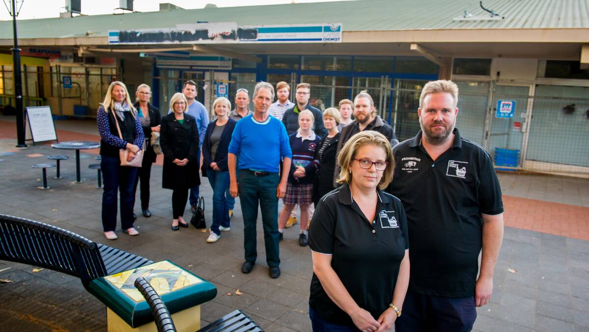 Former Curtin bottleshop owners Michelle and Paul Cains with other local business owners and residents. The group say their residents association, which is currently protesting an approved redevelopment of the Curtin shops (background), doesn't represent their views. Picture: Elesa Kurtz