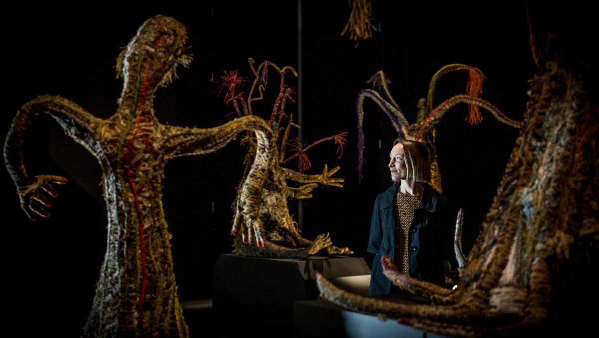  The National Museum of Australia's curator of Indigenous Knowledges, Caroline Edwards, with a series of eight life-sized figures created by the Tjanpi Desert Weavers from the remote central and western deserts. Picture: Karleen Minney