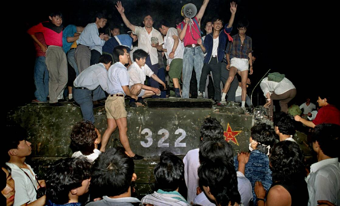 Civilians hold rocks as they stand on a government armoured vehicle near Changan Boulevard in Beijing on June 4, 1989. Picture: AP Photo/Jeff Widener