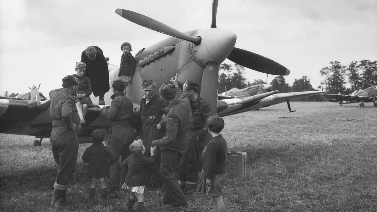 Ground crew and a Spitfire of No. 453 Squadron, RAAF, with French children in Normandy, France, June 1944. Picture: Australian War Memorial