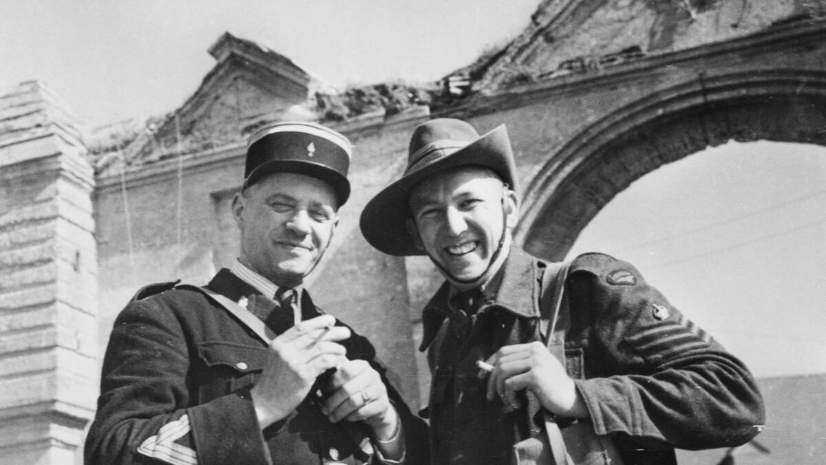 Flight Sergeant Fred Wood, RAAF, with the chief gendarme in a Normandy village, 1944. Picture: Australian War Memorial