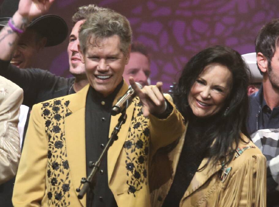 FILE - This Feb. 8, 2017 file photo shows country singer Randy Travis, left, and his wife Mary Travis at the "1 Night. 1 Place. 1 Time.: A Heroes and Friends Tribute to Randy Travis" in Nashville, Tenn. Travis, who survived a near fatal stroke in 2013 that left him with a limited ability to speak, released his first memoir, "Forever and Ever, Amen: A Memoir of Music, Faith and Braving the Storms of Life", chronicling his rise to fame. (Photo by Laura Roberts/Invision/AP, File)