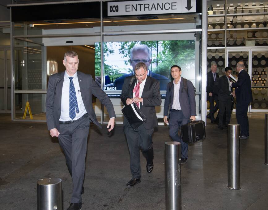 AFP officers depart the ABC studios on Wednesday after raiding them for information. Picture: Wolter Peeters