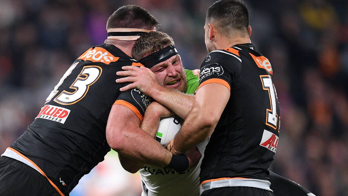 A few Tigers players give Raiders second-rower Elliott Whitehead a hug to congratulate him on his delightful kick that led to a try. Picture: AAP Image/Dan Himbrechts